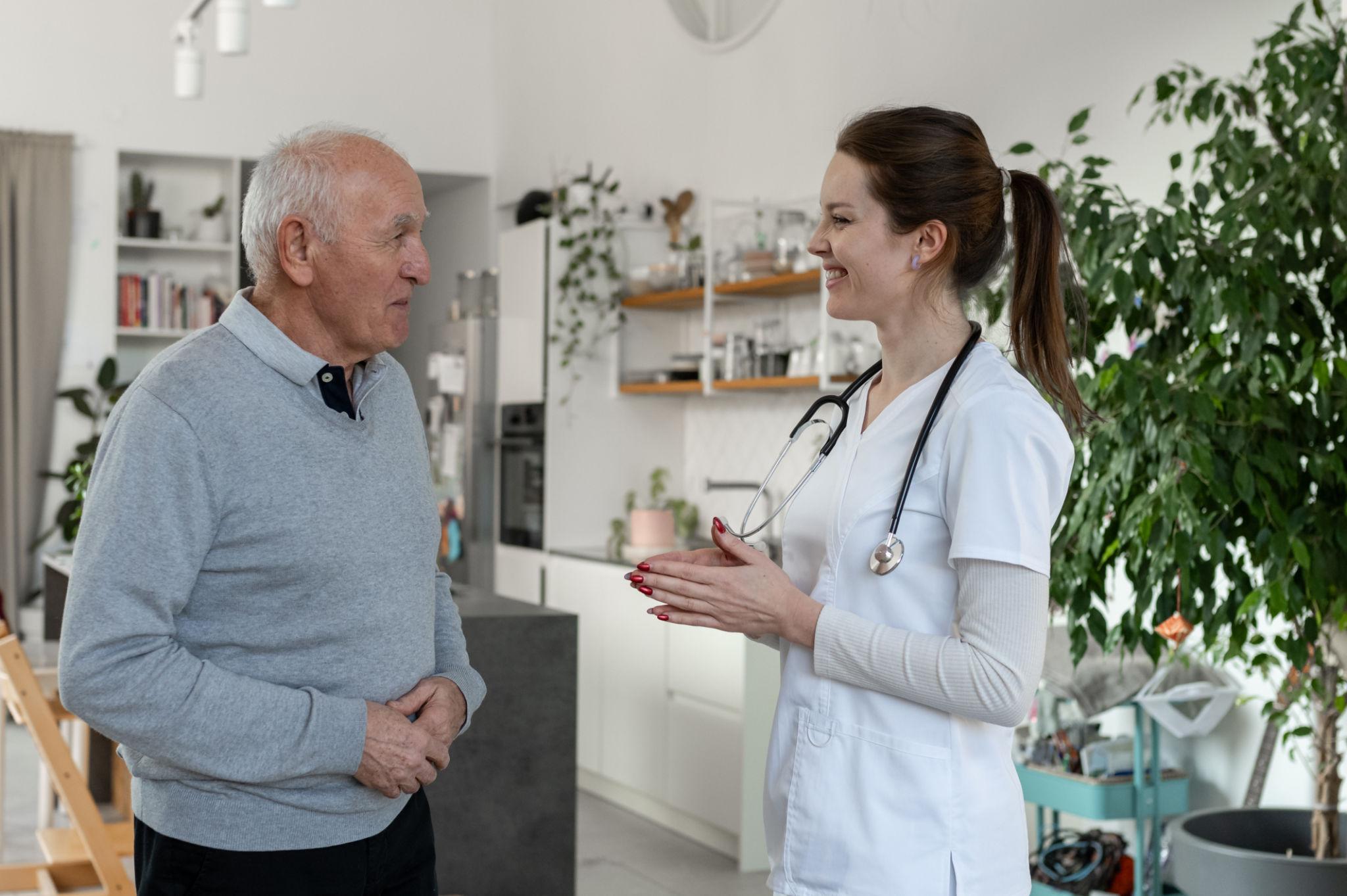 Doctor speaking with an older patient during a home visit